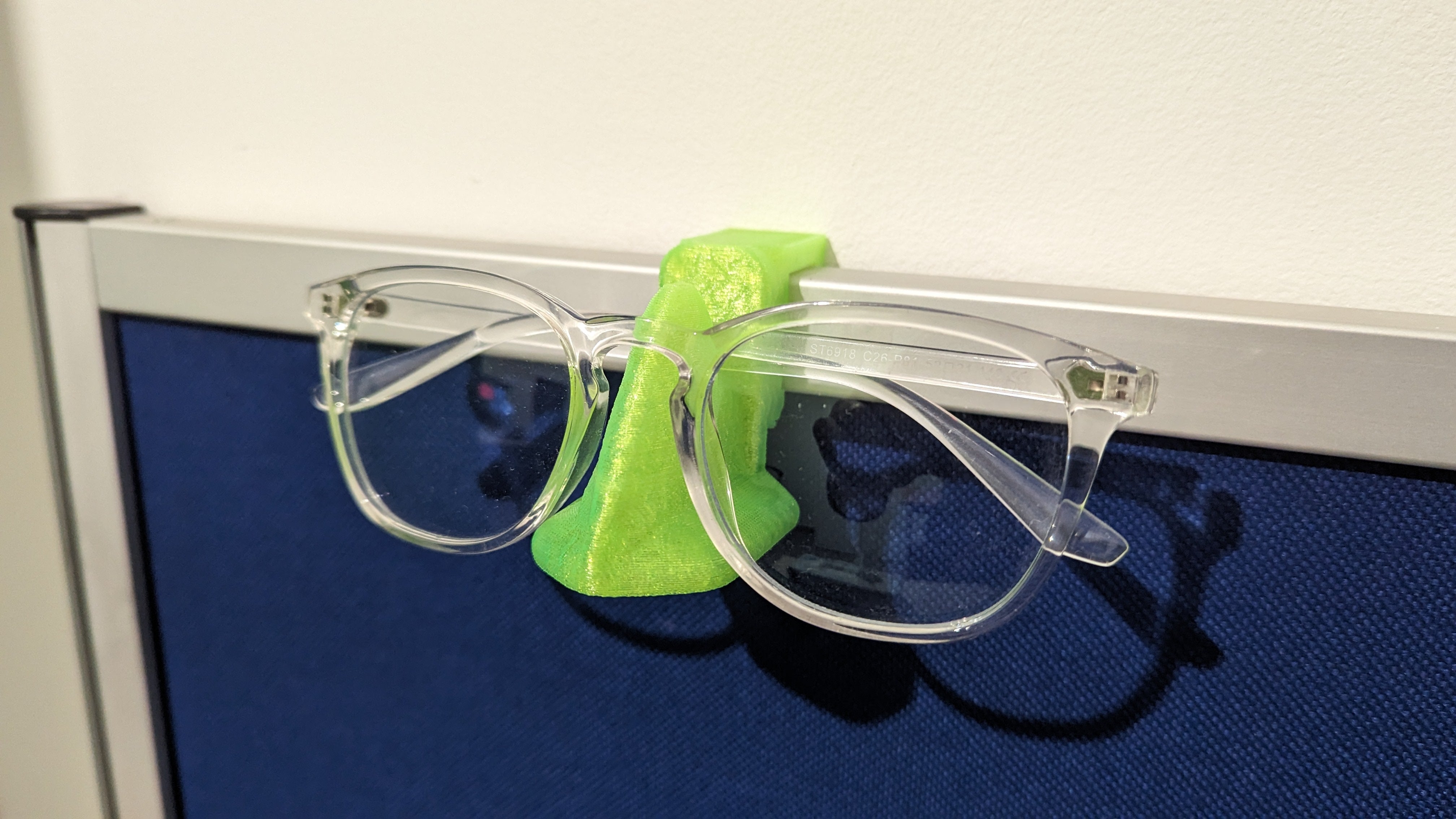 Nasenförmiger Brillenhalter zur Schreibtischabschirmung